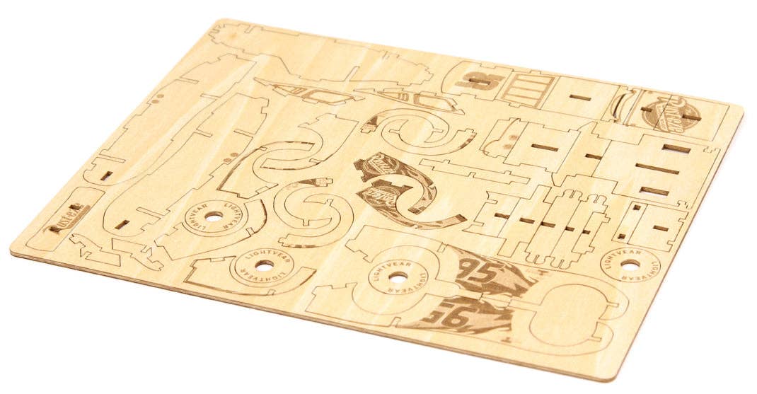 Wooden model kit with pre-cut pieces on a white background