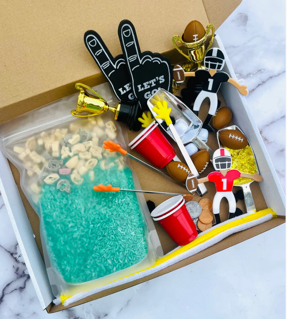 Football-themed sensory kit for kids, perfect for imaginative play. Includes mini footballs, bendable players, trophies, solo cups, foam fingers, helmets, scoops, yellow gems, pom-poms, pipe cleaners, tongs, coins, green rice, and football pasta. Encourages creativity and fine motor skills. Ages 3+, adult supervision recommended. Bin not included. Warning: small parts choking hazard.