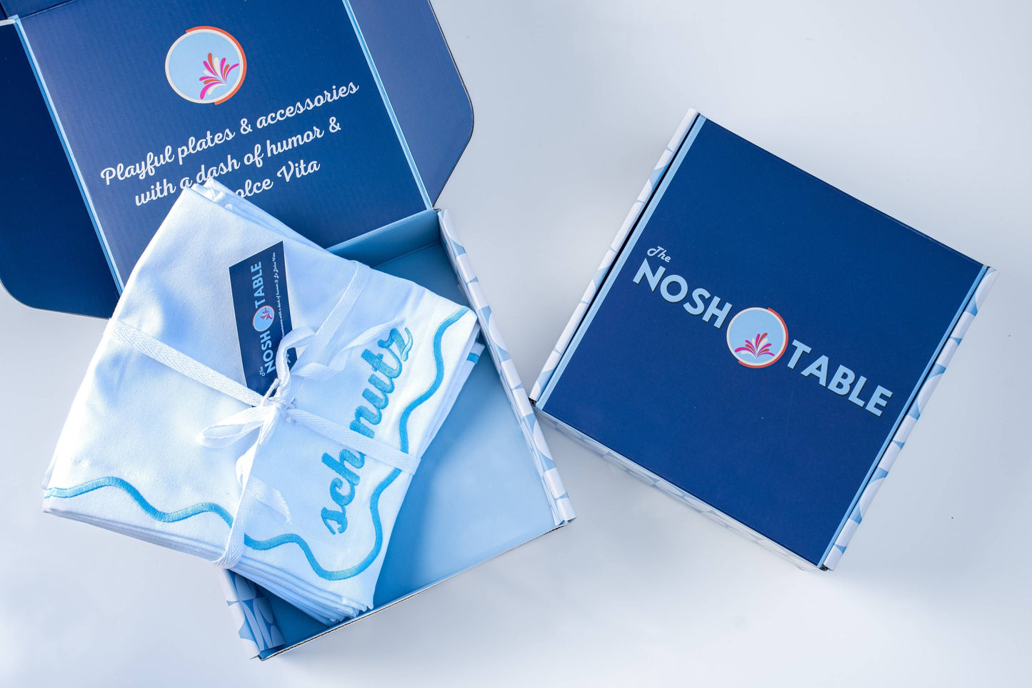 Set of 4 embroidered cotton napkins with a wavy border design, available in Bubbe Blue and Oy Vey Navy. Ideal for dinner parties, these 15-inch napkins are perfect for wiping up schmutz. Machine washable and ready for gifting, wrapped in ribbon.