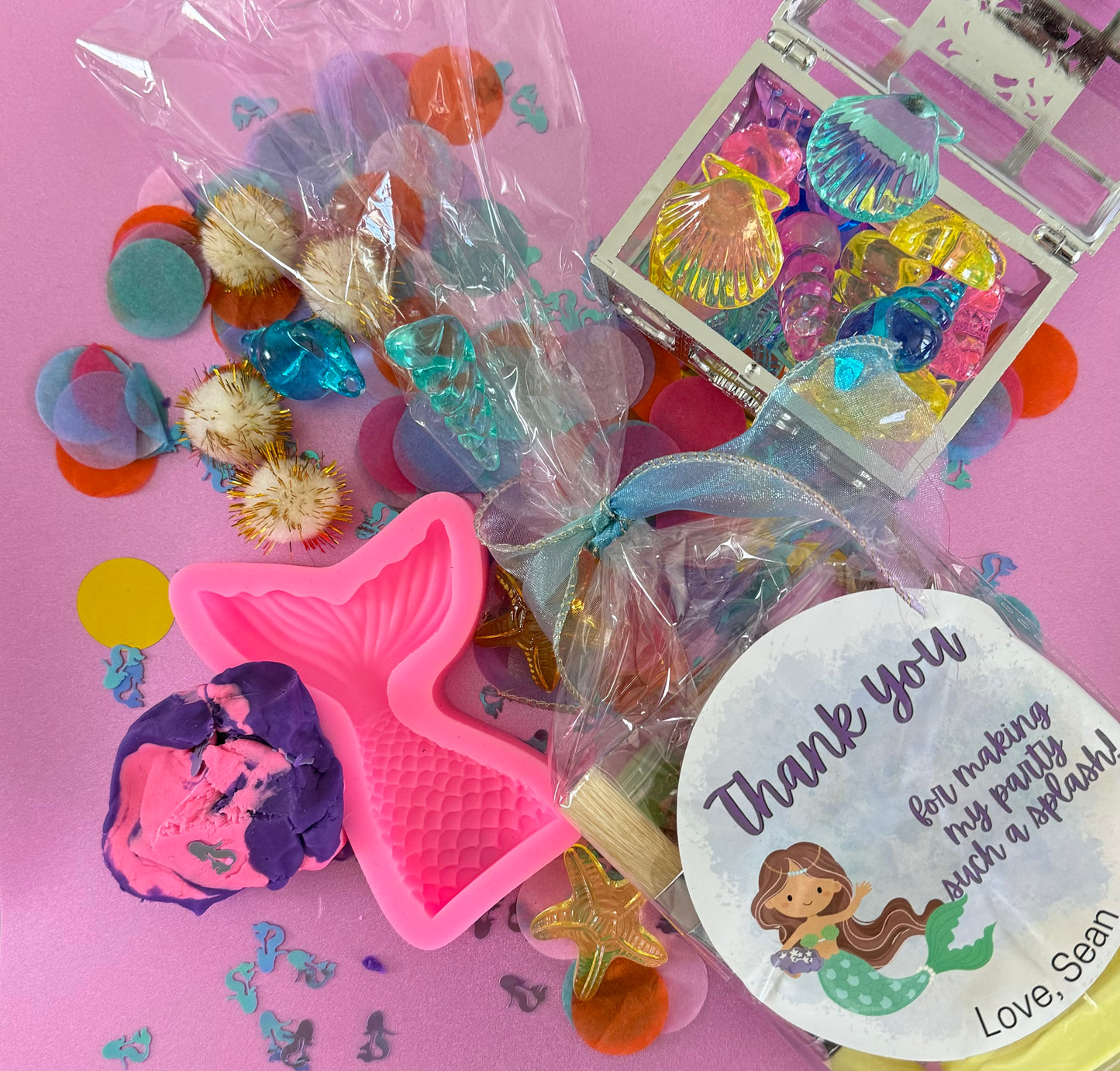 Mermaid Sensory Kit featuring Purple/Pink swirl glitter dough with mermaid confetti, enclosed in a gold or silver treasure chest. Includes gems, seashells, glitter pompoms, and a cookie cutter for creative play. Perfect for sensory development in kids