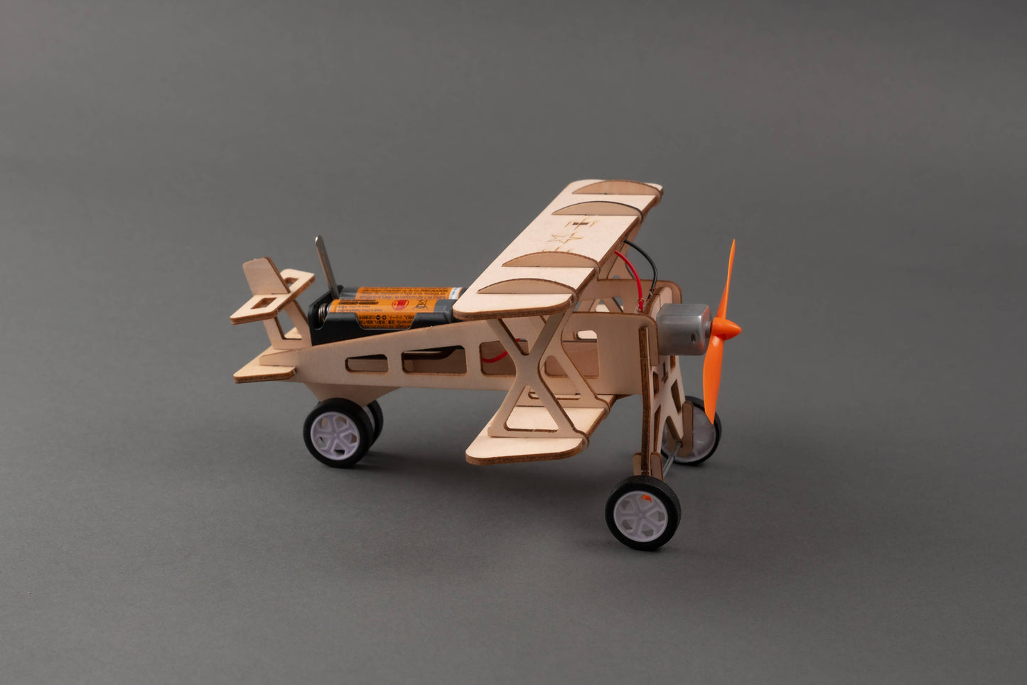 Child assembling wooden airplane with propeller