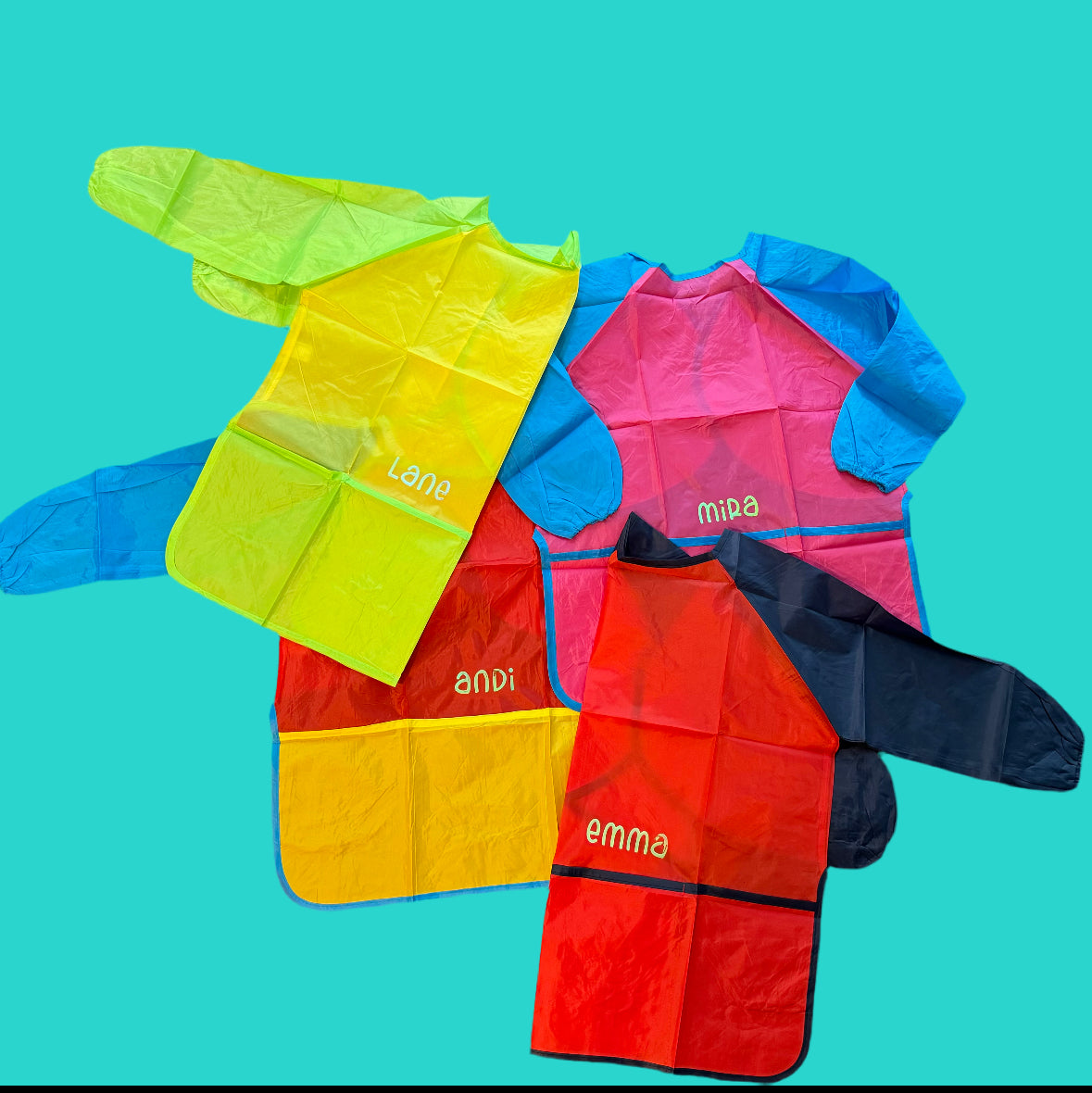 Custom Artist Smock for kids featuring a protective waterproof design, personalized with the child’s name. Ideal for pint-sized Picassos and little artists, this lightweight and durable plastic apron protects clothing from paint and glue. It includes a big front pocket for paint supplies and comes in various colors and font styles.