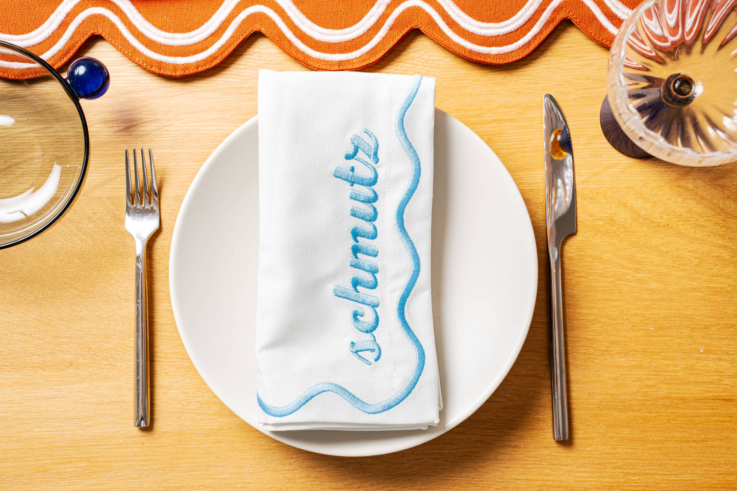 Set of 4 embroidered cotton napkins with a wavy border design, available in Bubbe Blue and Oy Vey Navy. Ideal for dinner parties, these 15-inch napkins are perfect for wiping up schmutz. Machine washable and ready for gifting, wrapped in ribbon.