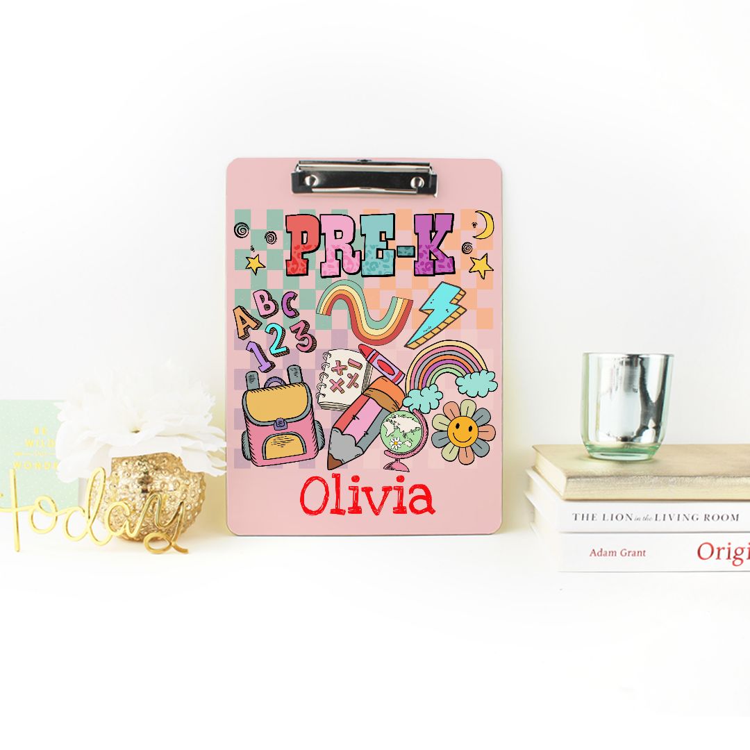 Customizable clipboard personalized with a child's name, perfect for teachers and pre-K classroom organization. This cute writing board features a smooth surface for easy writing, a chrome clip for activity sheets, and cheerful designs on both front and back. An ideal back-to-school gift for students, it helps keep track of documents, homework, and notes. Also makes a great personalized gift for teachers or teaching assistants, inspired by playful schoolhouse art.
