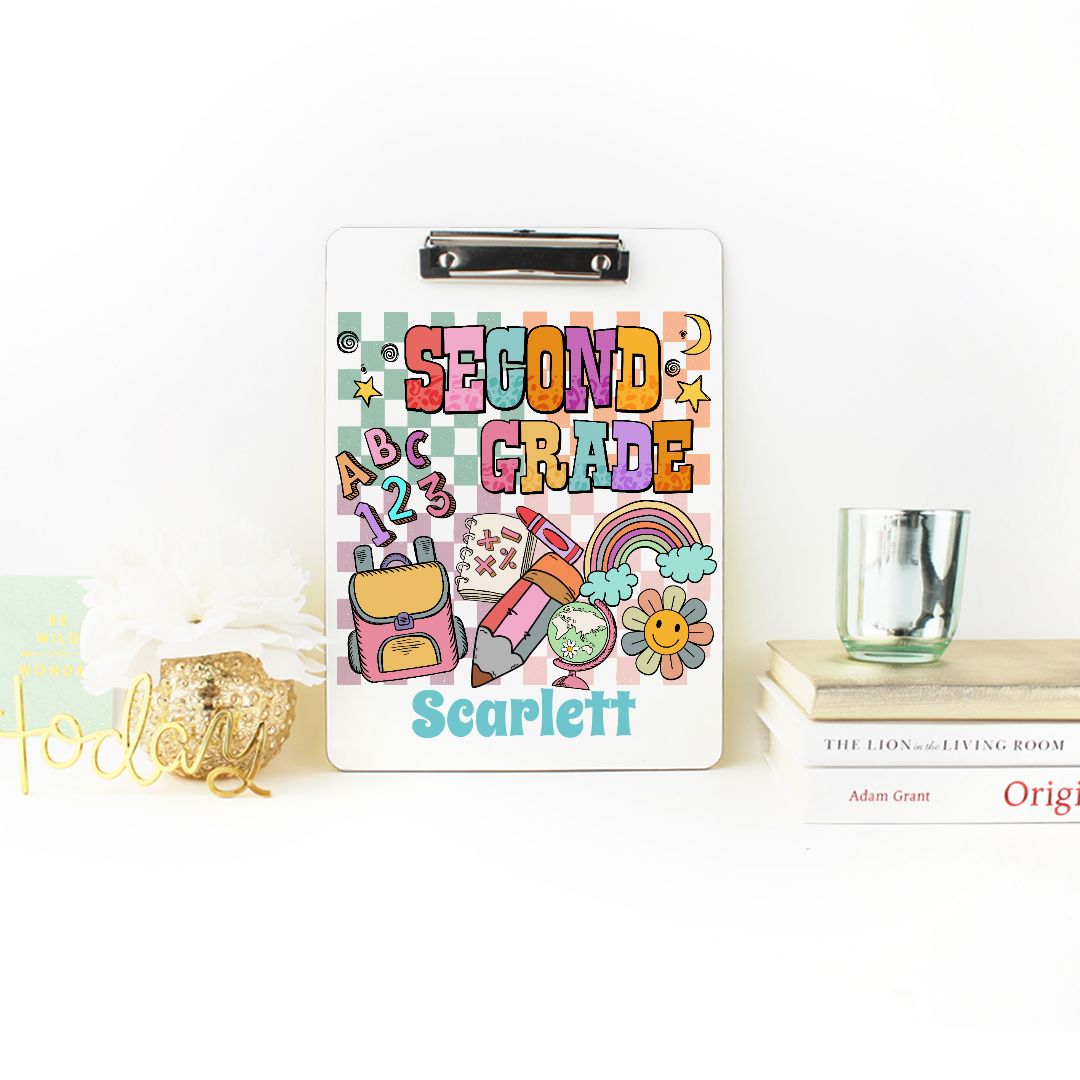 Custom clipboard personalized with a name, designed for teachers and students. Available in various colors, this cute clipboard features a smooth hard surface for writing and a chrome clip for holding activity sheets. Perfect as a back-to-school gift or second-grade graduation present, it helps keep documents, homework assignments, and notes organized. The cheerful design on the front and back adds a fun touch, making it an ideal classroom organization tool for second-grade teachers and teaching assistants.