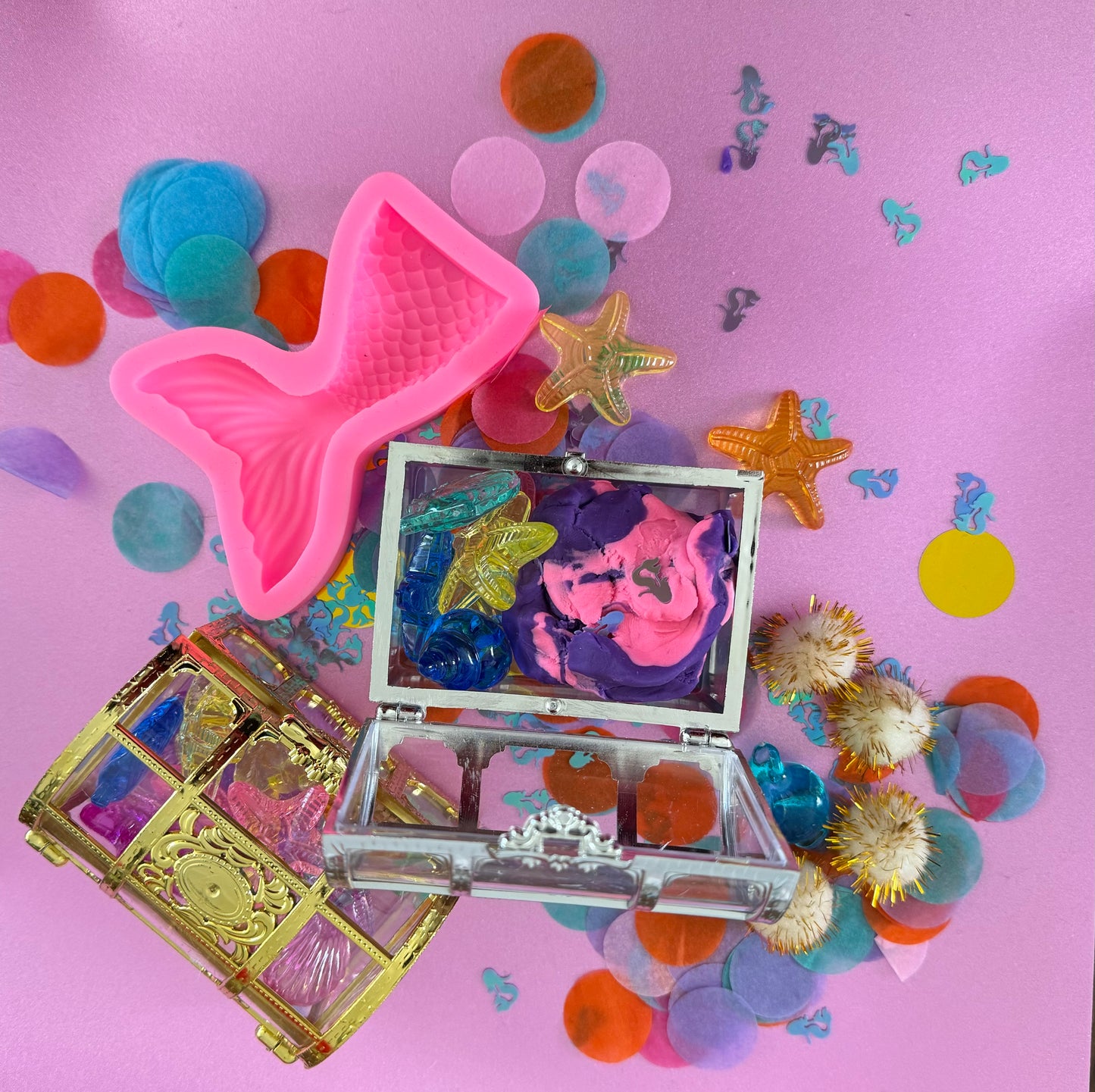 Mermaid Sensory Kit featuring Purple/Pink swirl glitter dough with mermaid confetti, enclosed in a gold or silver treasure chest. Includes gems, seashells, glitter pompoms, and a cookie cutter for creative play. Perfect for sensory development in kids