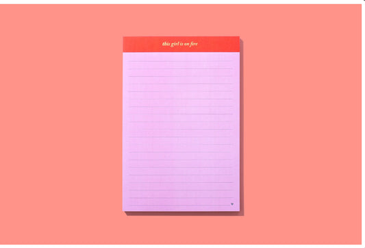 5.5" x 8.25" lined notebook with 75 sheets, imprinted with 'This girl is on fire.' Comes in shrink-wrap packaging. Perfect for note-taking or journaling. Imported.