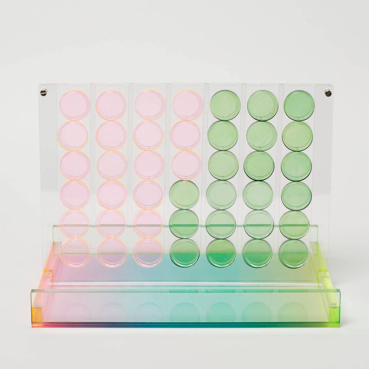 Modern Connect 4 game set made of transparent Lucite with colorful chips, folding into a sleek, display-worthy case by Sunnylife.