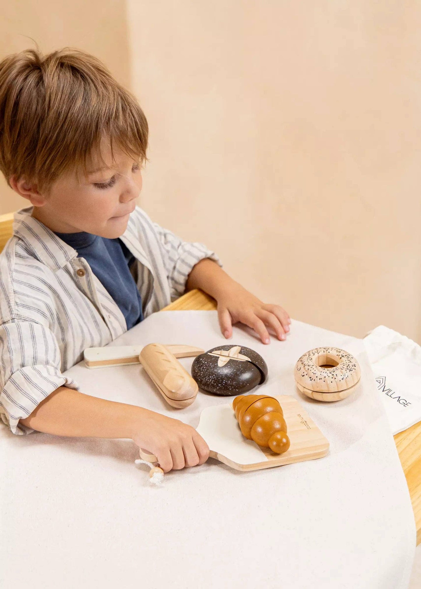 Wooden Bakery Playset for kids with baguette, croissant, pumpernickel, bagel, cutting board, and knife. Ideal for imaginative market play, helping children learn about different bread types, healthy eating, and colors. Perfect for pretend play with kitchen and market sets