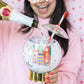 Shake up your holiday drinks with this 12 oz snow globe-shaped cup, featuring a holiday village and shakeable confetti. Perfect for festive parties or as a unique gift. BPA-free and hand wash only. Dimensions: 10.5" x 5" x 5" (including straw).