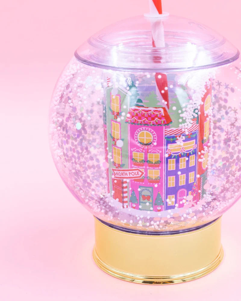 Shake up your holiday drinks with this 12 oz snow globe-shaped cup, featuring a holiday village and shakeable confetti. Perfect for festive parties or as a unique gift. BPA-free and hand wash only. Dimensions: 10.5" x 5" x 5" (including straw).