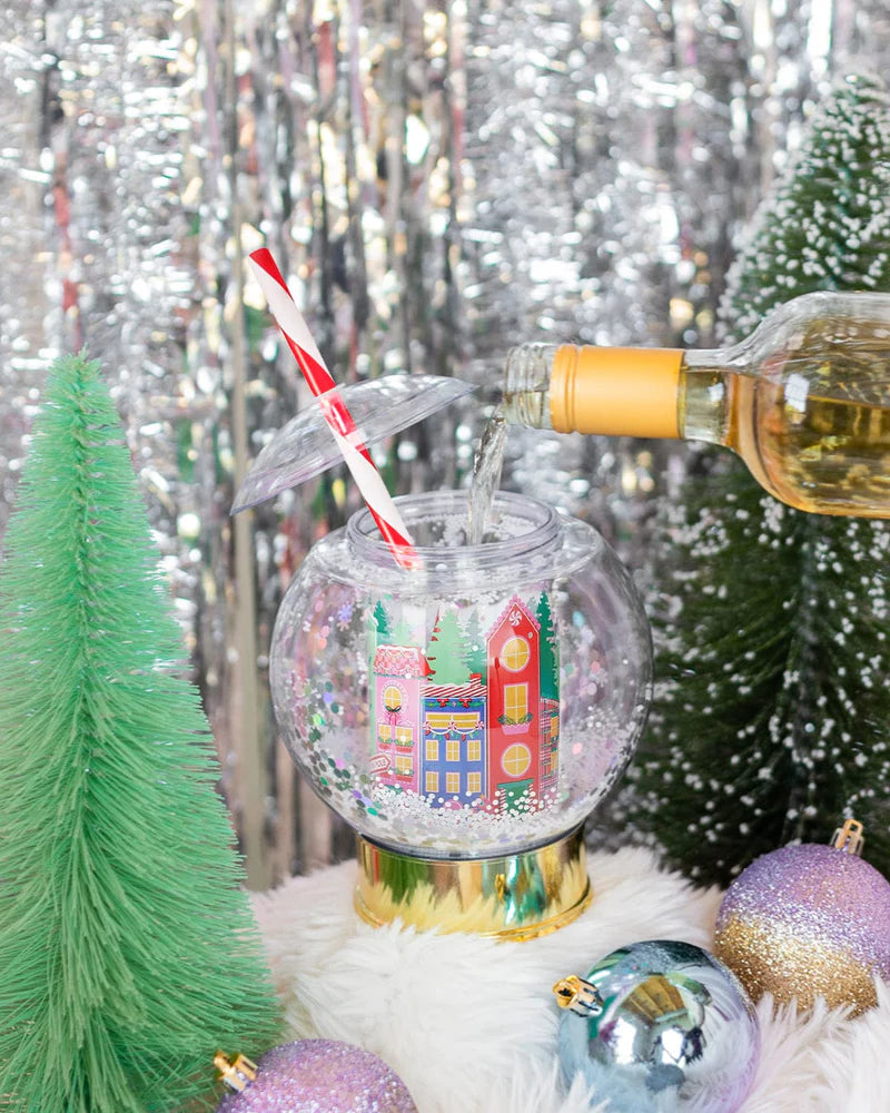 Shake up your holiday drinks with this 12 oz snow globe-shaped cup, featuring a holiday village and shakeable confetti. Perfect for festive parties or as a unique gift. BPA-free and hand wash only. Dimensions: 10.5" x 5" x 5" (including straw).