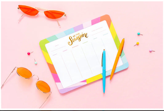 A stylish weekly planner and mousepad combo sized 7" x 9", featuring 52 sheets for organizing daily and weekly to-do lists. Each sheet is adorned with elegant gold foil imprinting, and the planner is shrink-wrapped for protection. Imported for quality.