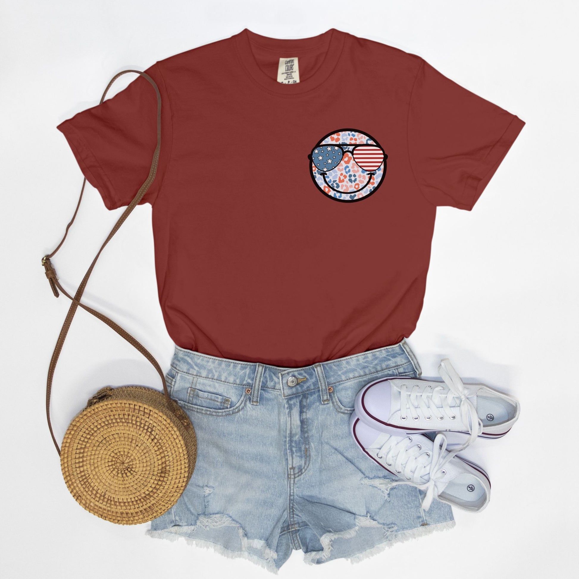 Retro smiley face sunglasses t-shirt featuring a patriotic design with American flag shades. Perfect for 4th of July celebrations, this vintage-style Comfort Colors tee is soft-washed, pre-shrunk, and available in unisex sizes. Show off 90s nostalgia with this fun and comfortable USA flag shirt, ideal for summer BBQs, fireworks, and family gatherings.
