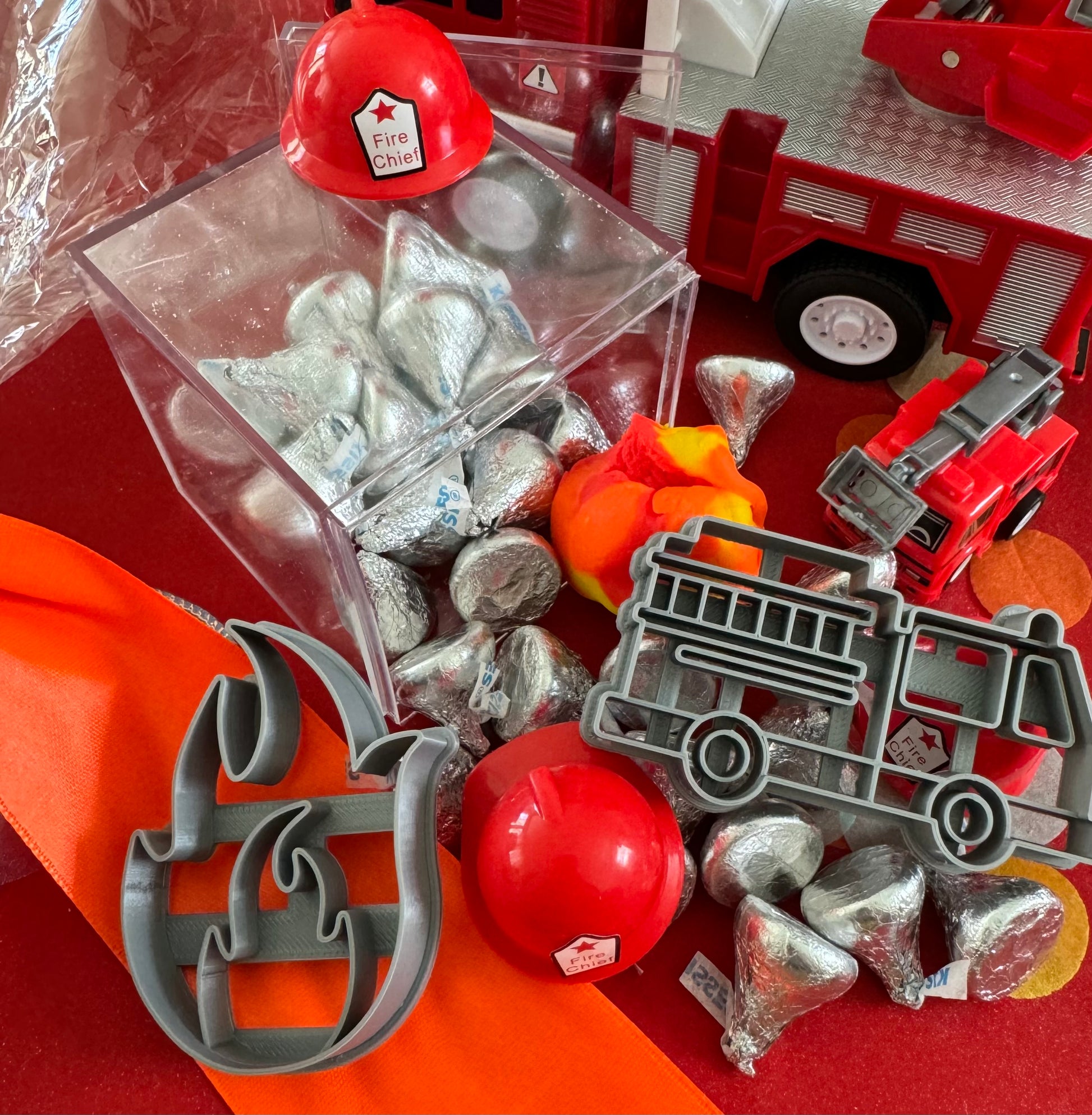 Delight in our Firetruck Themed candy favor, perfect for birthdays and firehouse play dates. This magical treat comes in a perfectly sized square plastic box filled with chocolate 'kisses' themed with firetruck labels. Each box is wrapped in cellophane and can include a thank you label. Explore more candy container options. Ideal for fire truck, firefighter, and tractor-themed parties, ensuring a delicious and fun addition to your celebration.