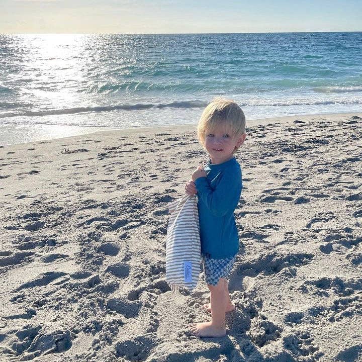 Child drying off with blue striped Kenzie Beach Towel