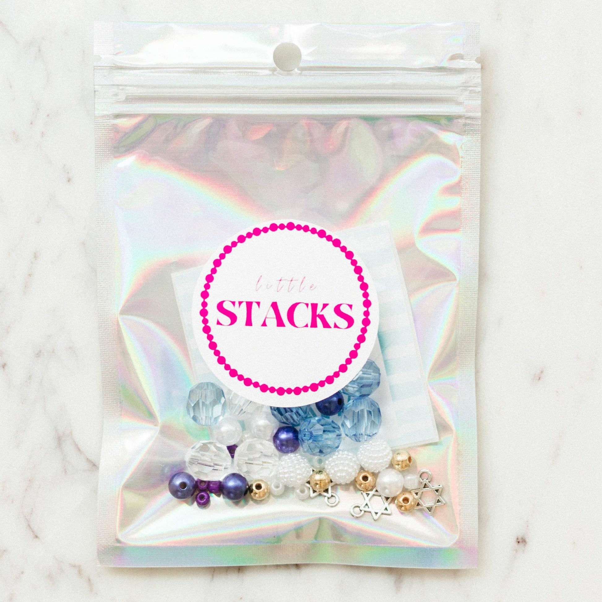 Create a festive Hanukkah stack with this bracelet kit featuring Star of David charms, pearls, and colorful beads. Makes 2+ bracelets (10-year-old sizing). WARNING: Small parts, choking hazard for children under 3. Adult supervision recommended.