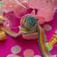 Unicorn-themed candy favor in a magical candy box featuring rainbow sour candy tails. Perfect for birthday parties and kids' celebrations. Enjoy a delightful sensory adventure with this fun and whimsical treat. Color may vary from photos.