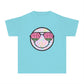 Kids’ summer t-shirt with a leopard print smiley face and watermelon sunglasses. Soft, durable cotton, available in youth sizes XS-XL. Perfect for summer activities.
