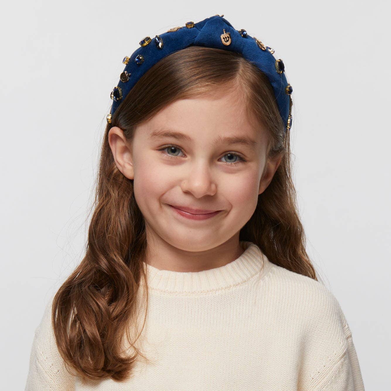 Indigo velvet kids' headband with 14k gold-plated dreidel charms and crystals, supporting Israel.