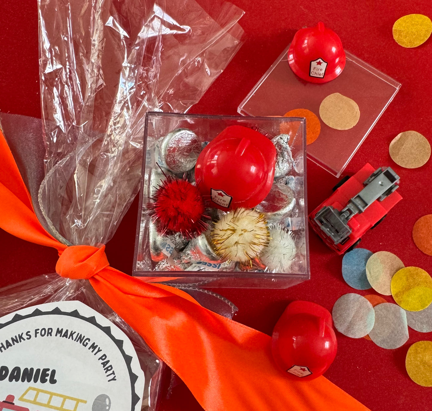Delight in our Firetruck Themed candy favor, perfect for birthdays and firehouse play dates. This magical treat comes in a perfectly sized square plastic box filled with chocolate 'kisses' themed with firetruck labels. Each box is wrapped in cellophane and can include a thank you label. Explore more candy container options. Ideal for fire truck, firefighter, and tractor-themed parties, ensuring a delicious and fun addition to your celebration.