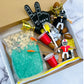 Football-themed sensory kit for kids, perfect for imaginative play. Includes mini footballs, bendable players, trophies, solo cups, foam fingers, helmets, scoops, yellow gems, pom-poms, pipe cleaners, tongs, coins, green rice, and football pasta. Encourages creativity and fine motor skills. Ages 3+, adult supervision recommended. Bin not included. Warning: small parts choking hazard.