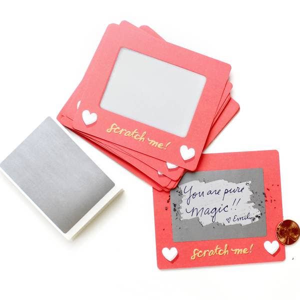 Set of 24 scratch-off lunchbox notes measuring 3.75” x 3.25”, featuring a Scratch-a-Sketch design. Each card includes a blank space for writing personalized messages and a To/From section on the back. Comes with 24 scratch-off stickers for a fun reveal of your hidden message. Perfect for slipping into lunch bags or coat pockets, these tiny notes are packaged in a clear plastic box with dimensions of L 5.25” x W 3.75” x H 1” and include directions for use, making them an ideal surprise for someone special.