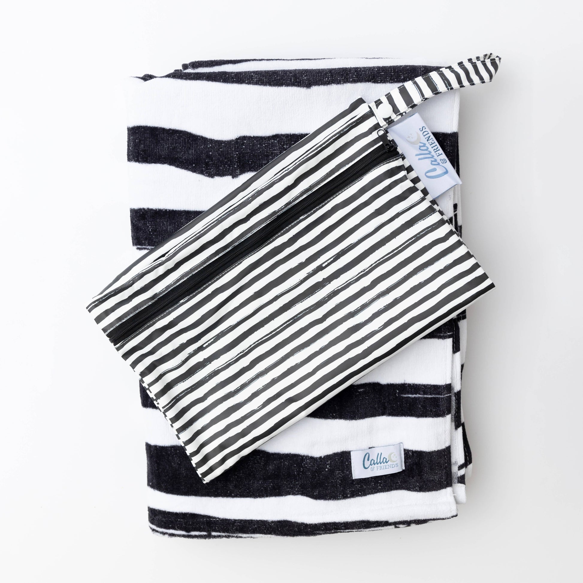 Kenzie Beach Towel and wet bag set laid out beside pool toys