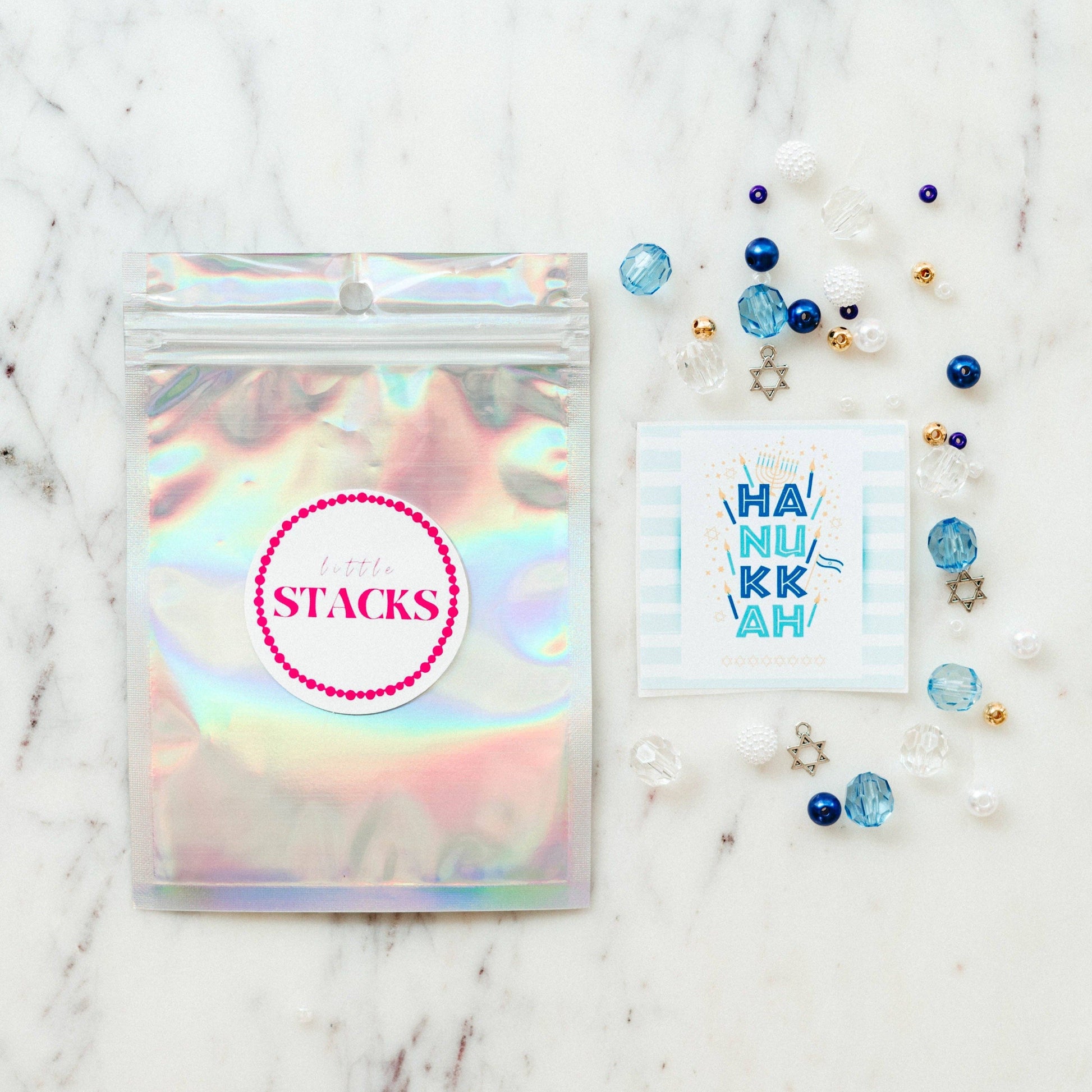 Create a festive Hanukkah stack with this bracelet kit featuring Star of David charms, pearls, and colorful beads. Makes 2+ bracelets (10-year-old sizing). WARNING: Small parts, choking hazard for children under 3. Adult supervision recommended.