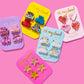 Set of 4 mini hair clips, each measuring 1.25 inches, ideal for stylish half-up hairstyles or adding a cute touch to any outfit. Includes 2 pink confetti clips and 2 pink acetate acid clips, presented on a 3.5" x 6.25" backer card with a gold ric rac ribbon hanger.