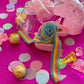Unicorn-themed candy favor in a magical candy box featuring rainbow sour candy tails. Perfect for birthday parties and kids' celebrations. Enjoy a delightful sensory adventure with this fun and whimsical treat. Color may vary from photos.
