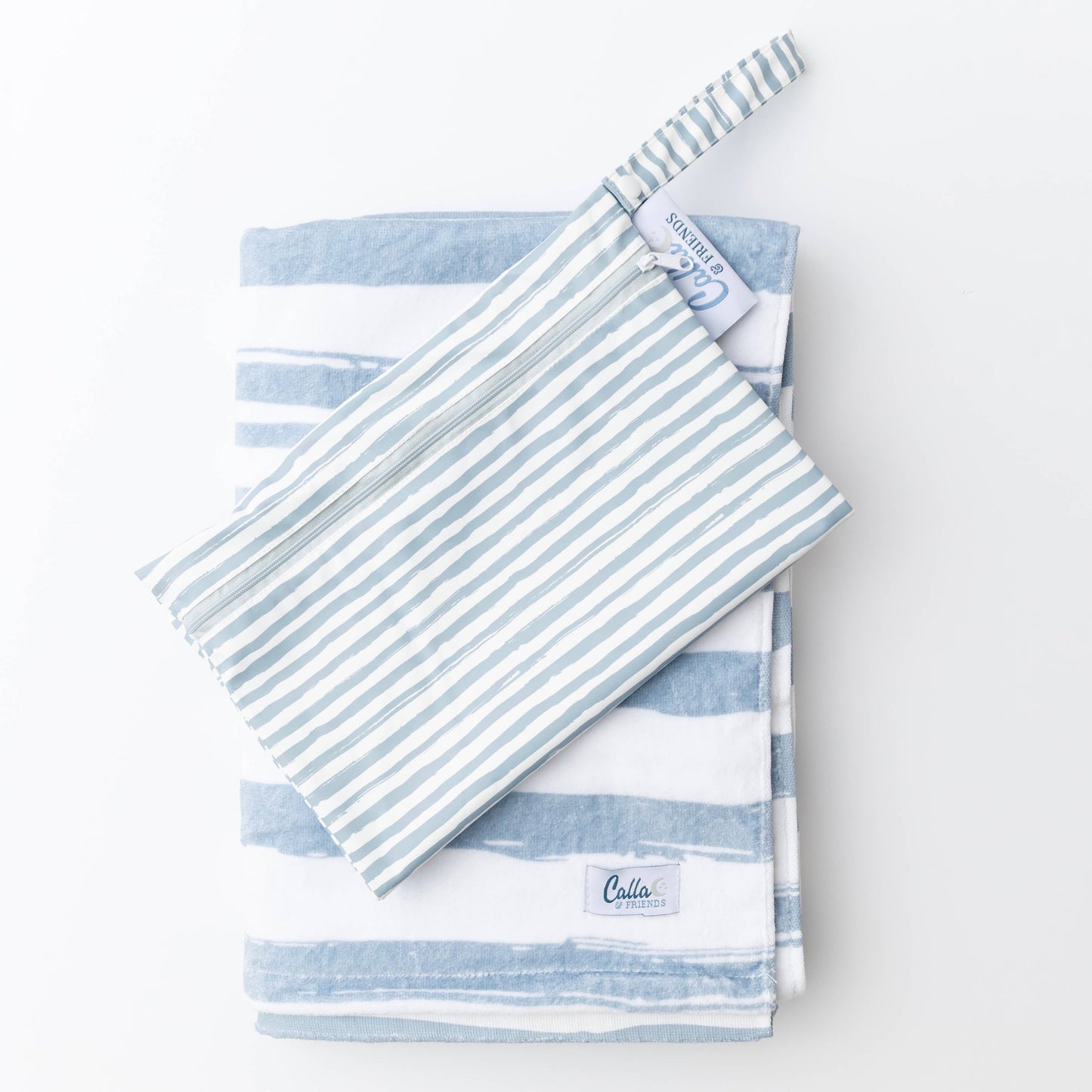 Blue striped Kenzie Beach Towel with matching wet bag on sand