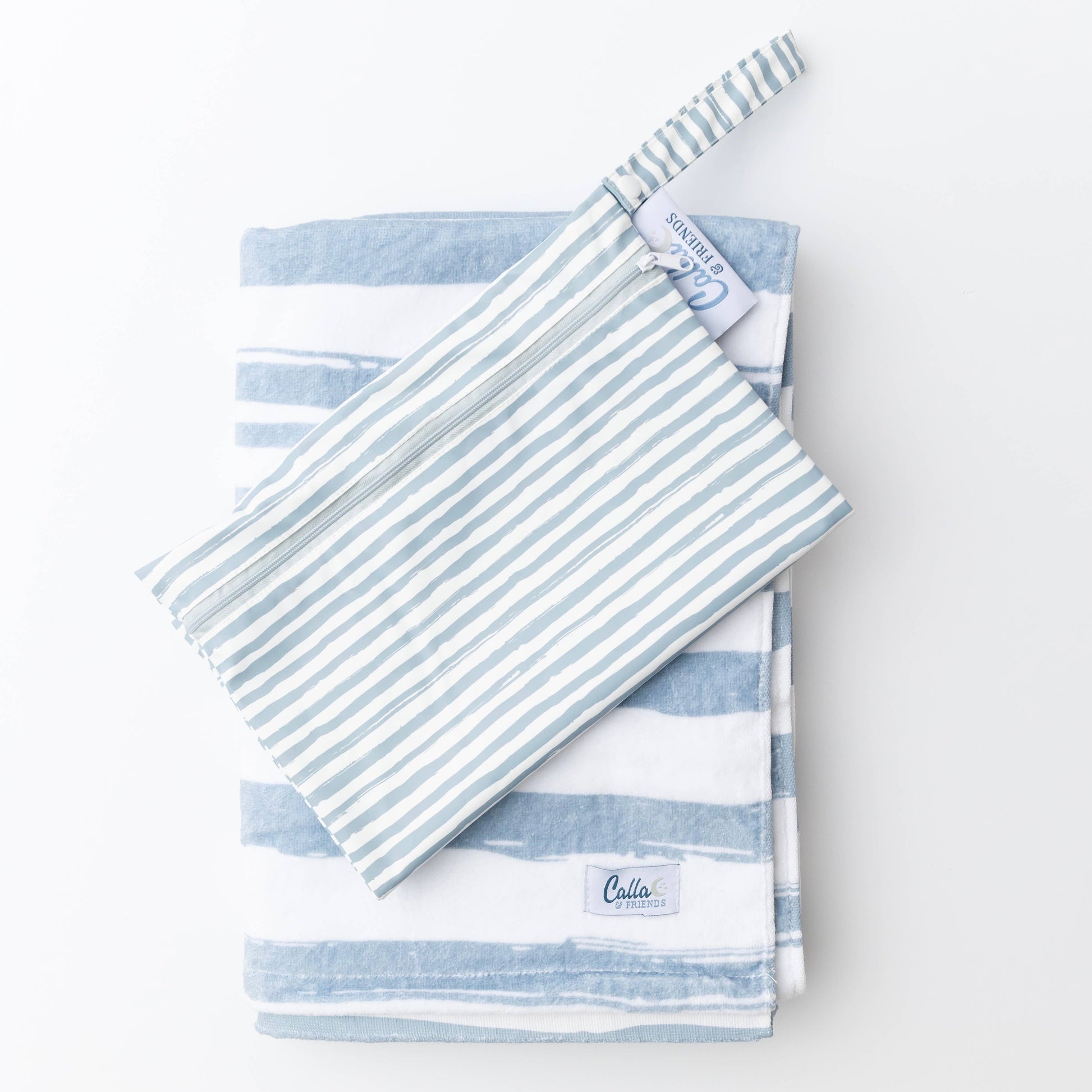 Blue striped Kenzie Beach Towel with matching wet bag on sand