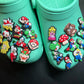 Turquoise shoes with colorful character pins on a black background