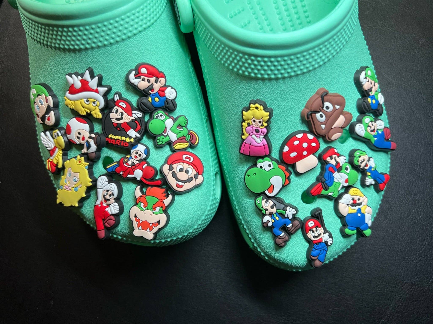 Turquoise shoes with colorful character pins on a black background