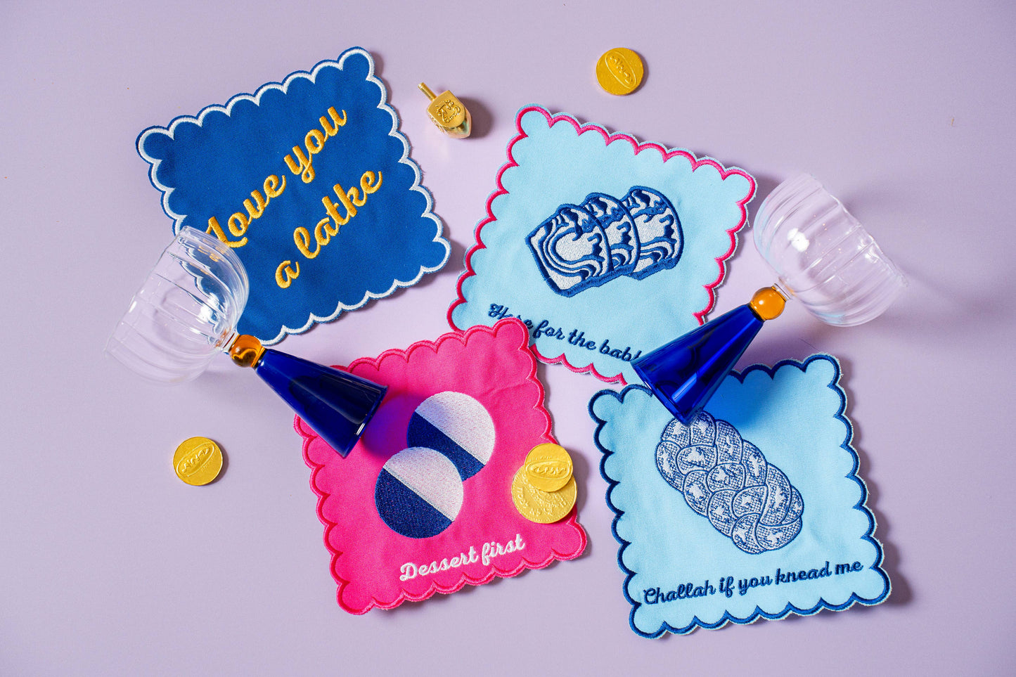 Hanukkah gift set featuring 4 porcelain nosh plates and 4 cotton/linen cocktail napkins, each with playful designs. Perfect for festive meals and gifting. Includes a custom gift box, ideal for holiday celebrations.