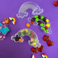 Trolls-themed birthday party favors featuring Poppy and Branch, enclosed in a rainbow-themed plastic box filled with Skittles. Perfect for celebrating and thanking guests, these candy favors are wrapped in cellophane with an optional thank you label. Great for playdates and available with other candy containers
