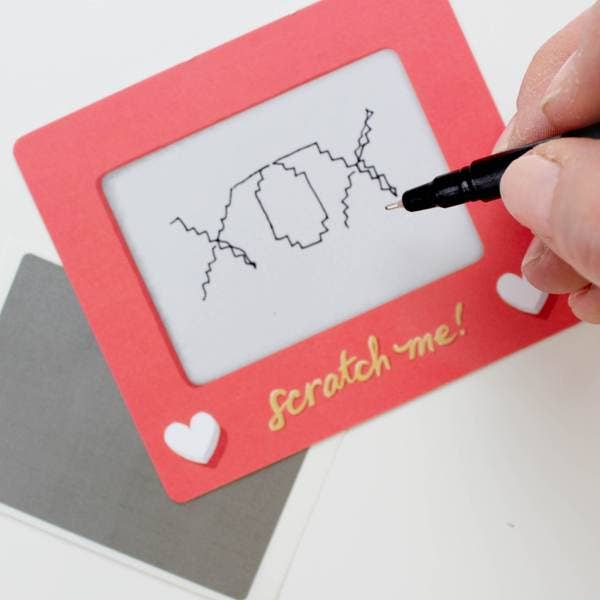 Set of 24 scratch-off lunchbox notes measuring 3.75” x 3.25”, featuring a Scratch-a-Sketch design. Each card includes a blank space for writing personalized messages and a To/From section on the back. Comes with 24 scratch-off stickers for a fun reveal of your hidden message. Perfect for slipping into lunch bags or coat pockets, these tiny notes are packaged in a clear plastic box with dimensions of L 5.25” x W 3.75” x H 1” and include directions for use, making them an ideal surprise for someone special.