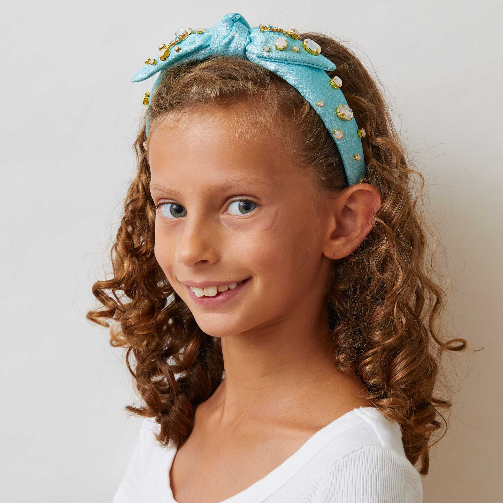 Lele Sadoughi x Wicked Headband, NY Broadway Collaboration, Wicked 25th Anniversary Accessories, Glinda-Inspired Magical Wand Design, Bubble Blue Poly Blend Headband, Hand-Embellished Oval Opals & Round Crystals, 14k Gold-Plated Wand Charms, Comfort Fit Band for Ages 3-9, Trademark Logo Charm, Spot Clean, Custom Collaboration Pouch Included, Stylish & Comfortable NYC Design, High-Quality Fabrics & Hand-Sewn Trims, Iconic Wicked Accessories, Perfect Gift for Broadway Fans, Unique Collaboration Headband, Lele