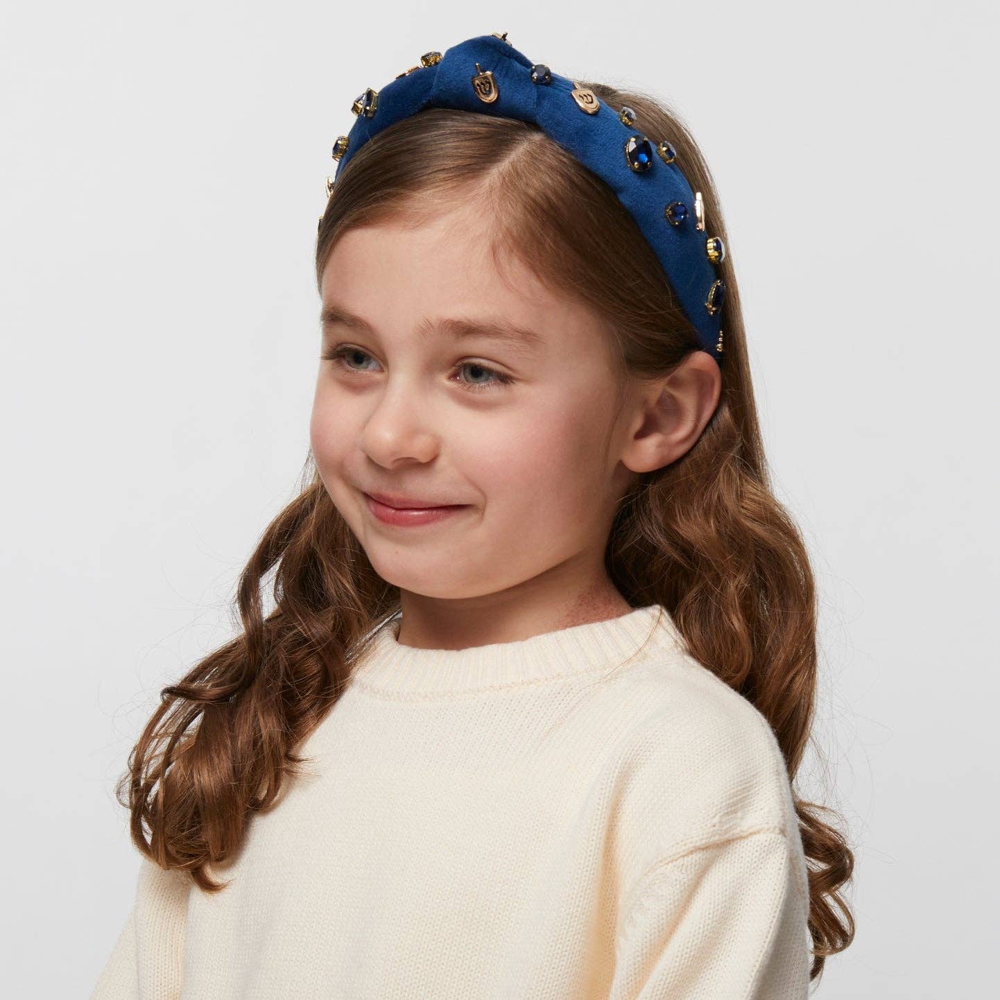 Indigo velvet kids' headband with 14k gold-plated dreidel charms and crystals, supporting Israel.
