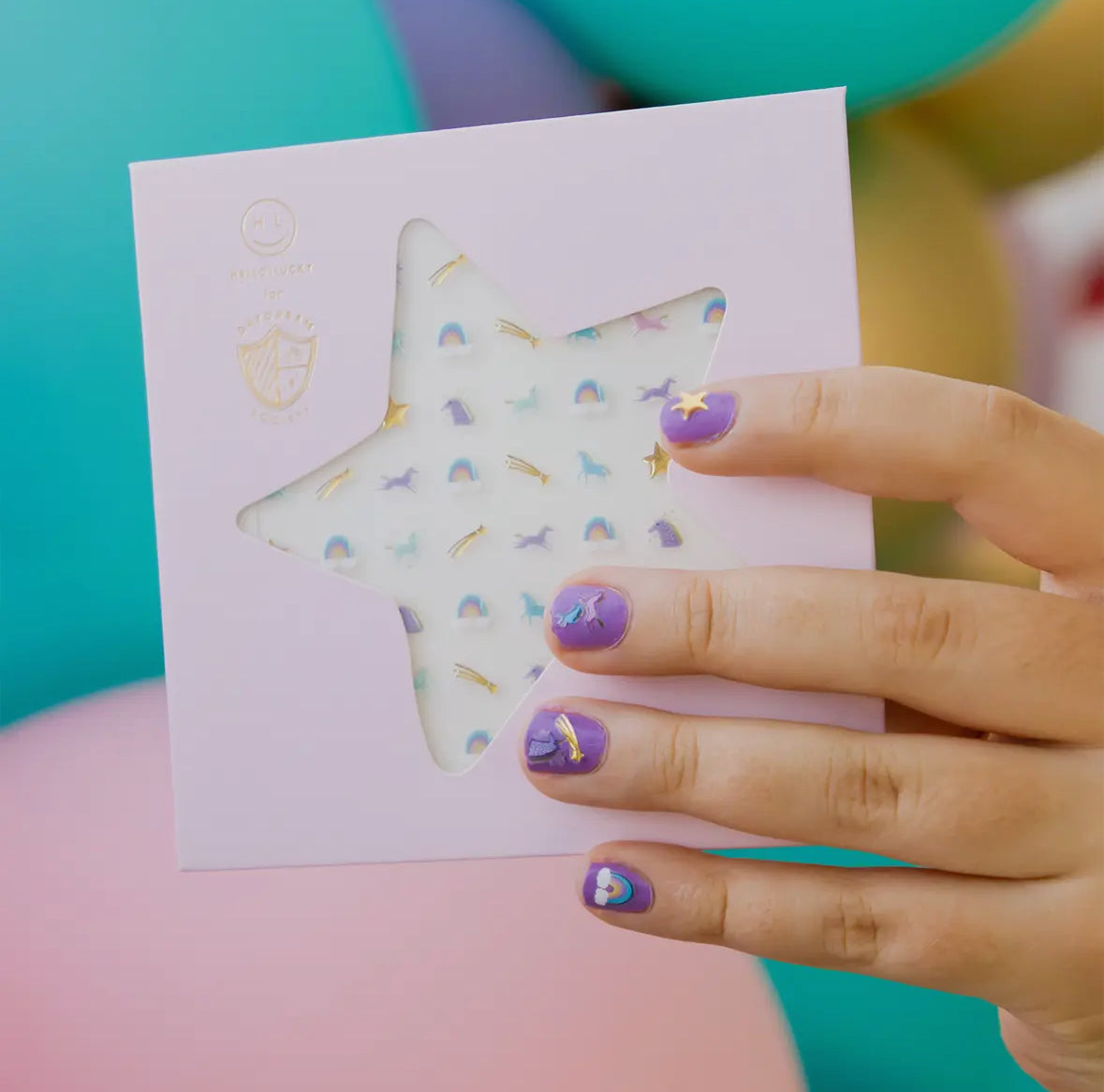 Unicorn and rainbow-themed press-on nail stickers, illustrated by Hello!Lucky for Daydream Society. Includes 1 sheet of 100 safe, non-toxic stickers. Packaged in a card stock envelope for easy use and magical nail transformations.