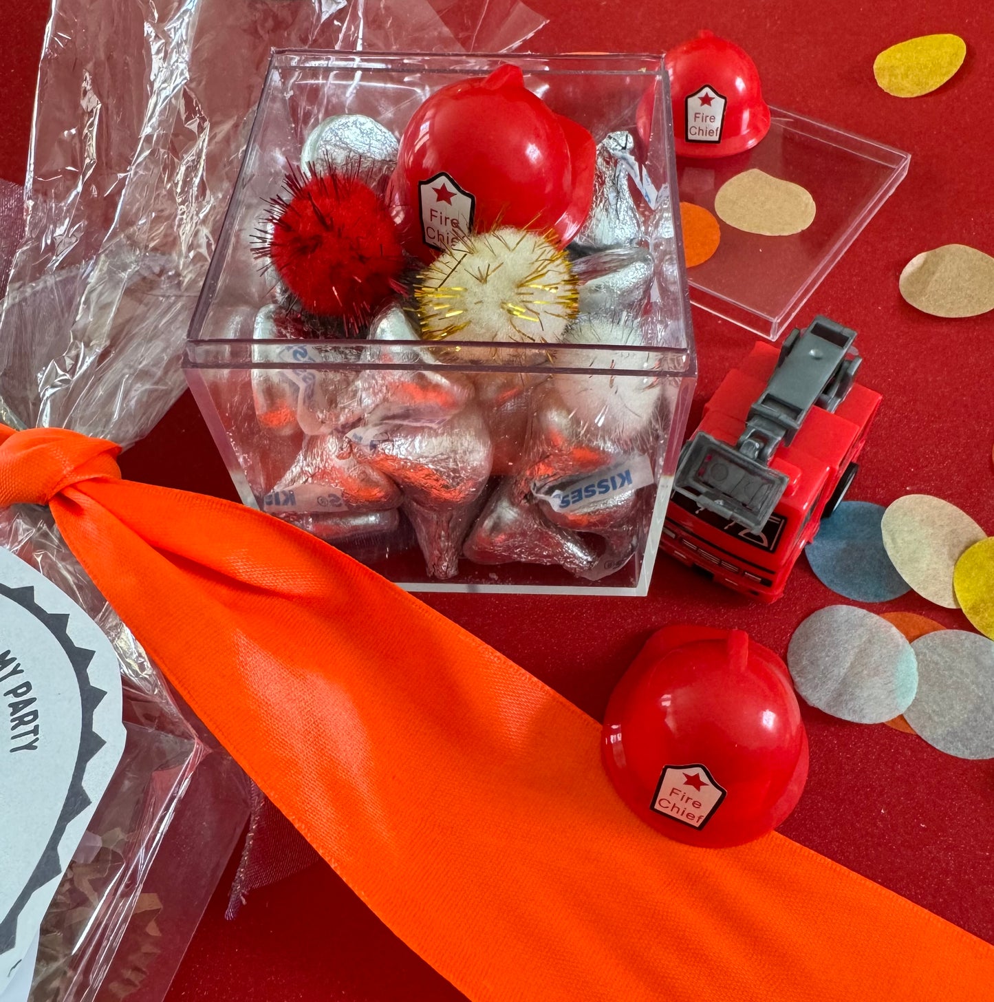 Delight in our Firetruck Themed candy favor, perfect for birthdays and firehouse play dates. This magical treat comes in a perfectly sized square plastic box filled with chocolate 'kisses' themed with firetruck labels. Each box is wrapped in cellophane and can include a thank you label. Explore more candy container options. Ideal for fire truck, firefighter, and tractor-themed parties, ensuring a delicious and fun addition to your celebration.