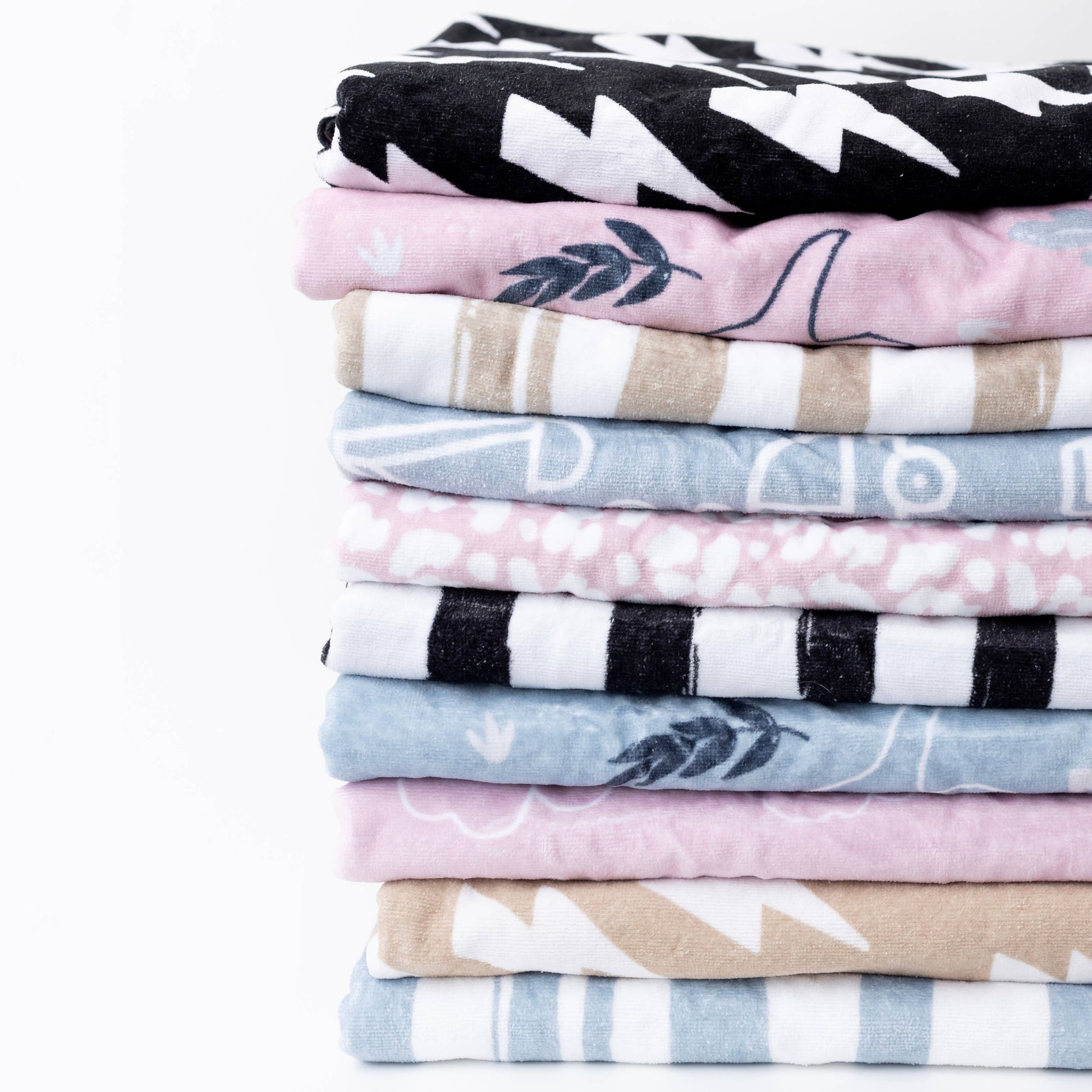 Stack of folded fabric swatches with various patterns on a white background