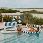 FUNBOY Floating Cabana Bar measuring nearly 6ft long, perfect for outdoor entertainers and summer parties. This inflatable drink station features a navy blue and white cabana stripe fabric sun shade that helps keep drinks and ice cold. With dual circular drink holders for ice or beverages and four additional cup holders, it’s ideal for mixing cocktails in the pool or setting up a pop-up drink station on a table.
