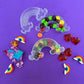 Trolls-themed birthday party favors featuring Poppy and Branch, enclosed in a rainbow-themed plastic box filled with Skittles. Perfect for celebrating and thanking guests, these candy favors are wrapped in cellophane with an optional thank you label. Great for playdates and available with other candy containers