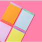 Assortment of colorful motivational notepads on a pink background, featuring phrases like 'Prove Them Wrong, Babe,' 'Love Like Jesus,' 'Believe in Her,' and 'Be Strong, Be Courageous.' Each notepad comes in different colors including yellow, green, pink, and purple, ideal for inspiring notes and personal reflections.
