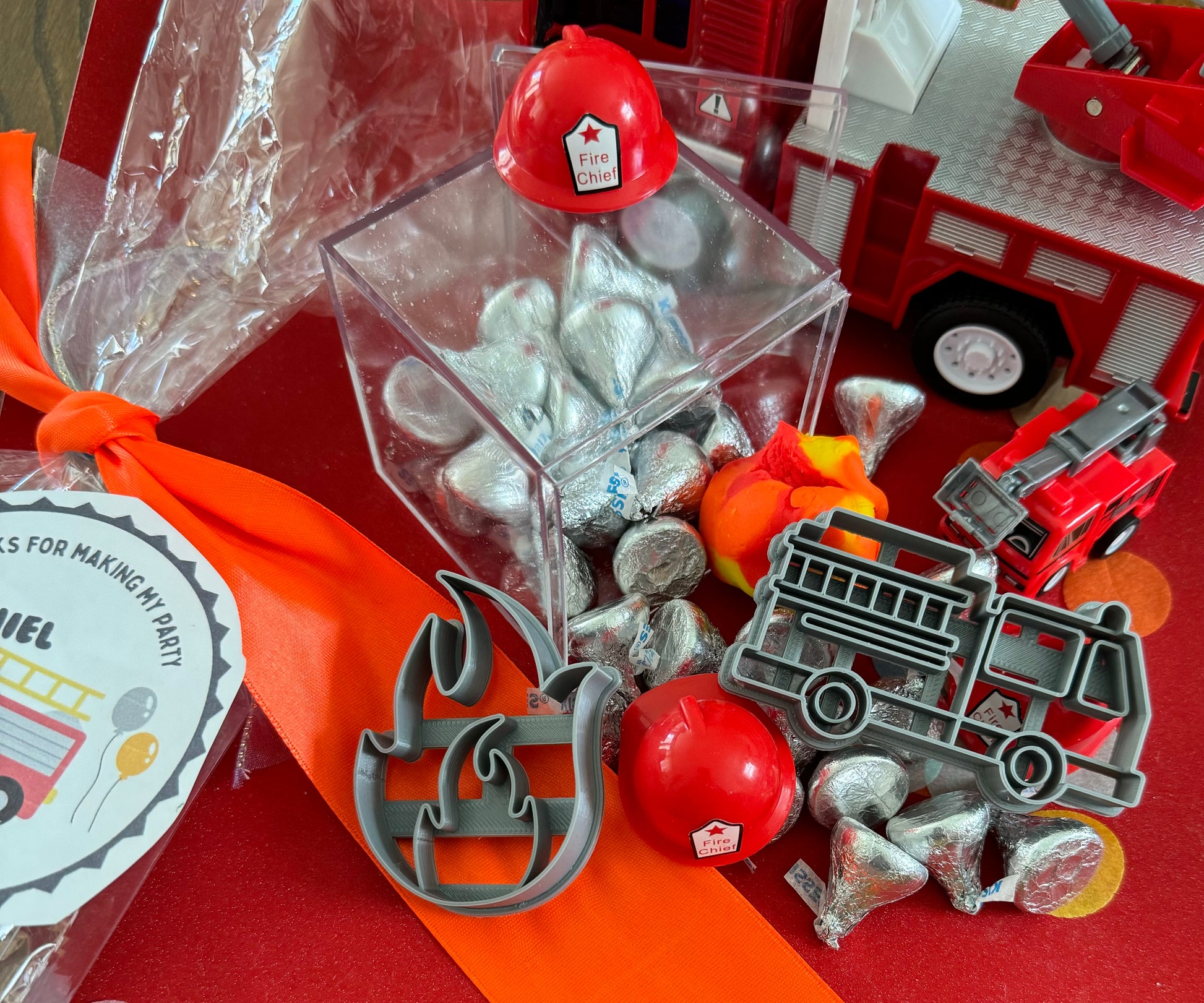 Delight in our Firetruck Themed candy favor, perfect for birthdays and firehouse play dates. This magical treat comes in a perfectly sized square plastic box filled with chocolate 'kisses' themed with firetruck labels. Each box is wrapped in cellophane and can include a thank you label. Explore more candy container options. Ideal for fire truck, firefighter, and tractor-themed parties, ensuring a delicious and fun addition to your celebration.