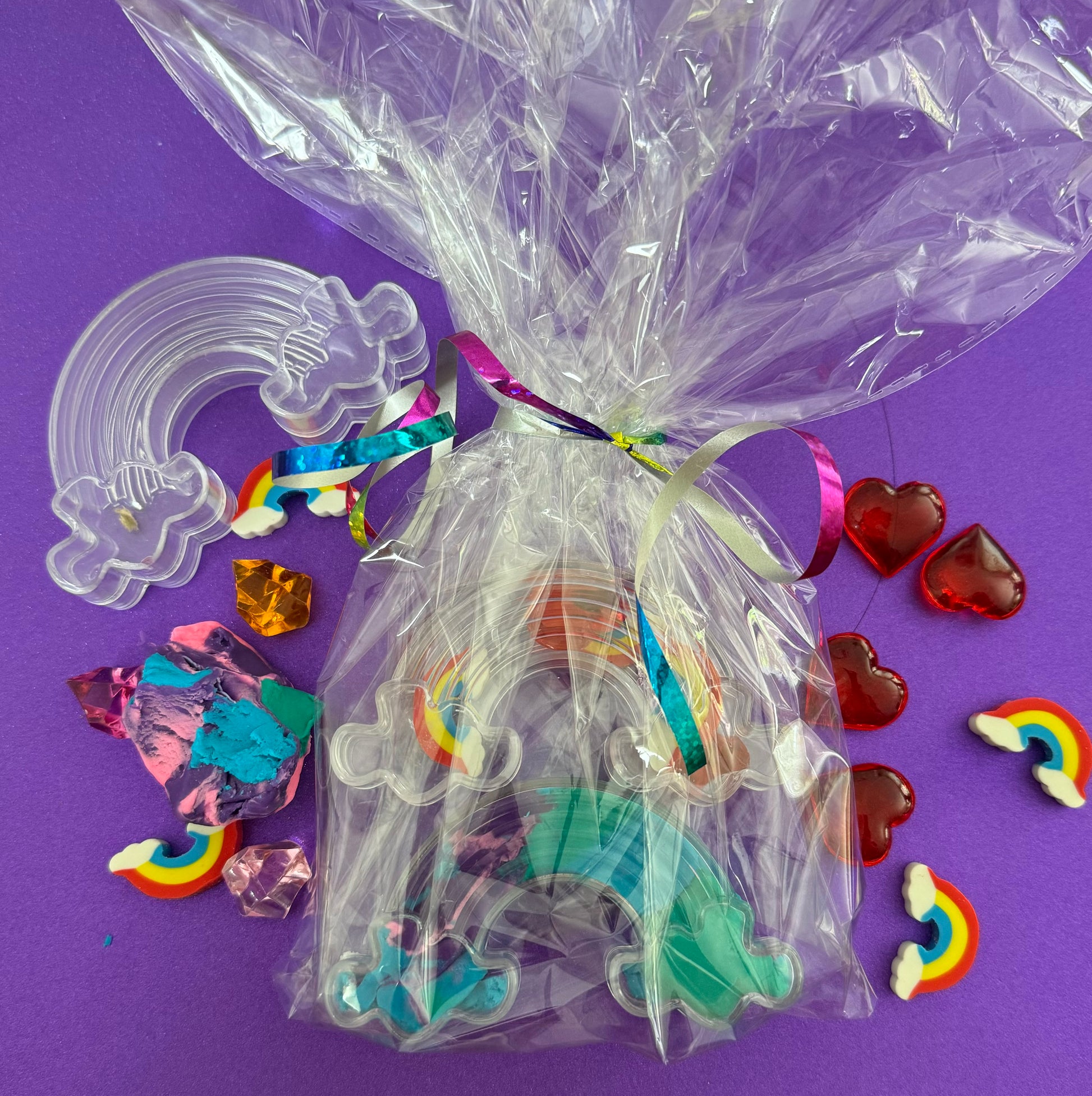 Rainbow sensory kit featuring handmade rainbow swirl glitter dough infused with confetti, miniature sensory charm mix, and soft glitter pompoms. Designed to engage senses and inspire creativity for toddlers and kids ages 3+. Promotes brain development, fine motor skills, and emotional growth. Includes small parts; parental supervision recommended.