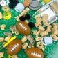 Football-themed sensory kit for kids, perfect for imaginative play. Includes mini footballs, bendable players, trophies, solo cups, foam fingers, helmets, scoops, yellow gems, pom-poms, pipe cleaners, tongs, coins, green rice, and football pasta. Encourages creativity and fine motor skills. Ages 3+, adult supervision recommended. Bin not included. Warning: small parts choking hazard.