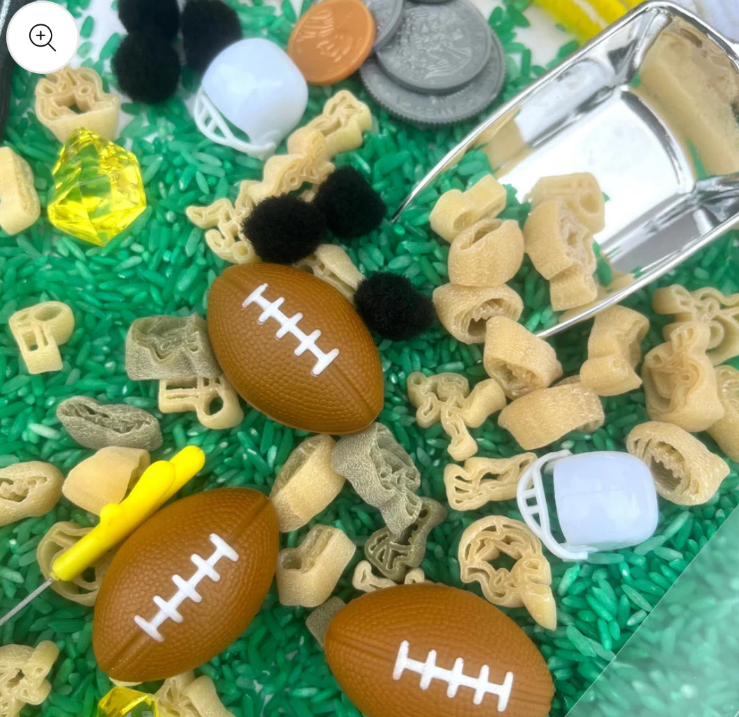 Football-themed sensory kit for kids, perfect for imaginative play. Includes mini footballs, bendable players, trophies, solo cups, foam fingers, helmets, scoops, yellow gems, pom-poms, pipe cleaners, tongs, coins, green rice, and football pasta. Encourages creativity and fine motor skills. Ages 3+, adult supervision recommended. Bin not included. Warning: small parts choking hazard.